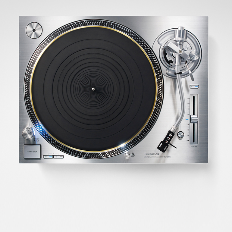 The turntable features a black platter with concentric circles and a tonearm positioned to the right.