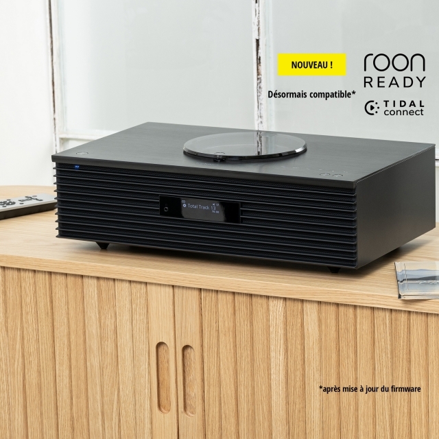 Système audio compact placé sur un meuble en bois, qui arbore les logos « roon ready » et « EISA Award 2022–2023 ».