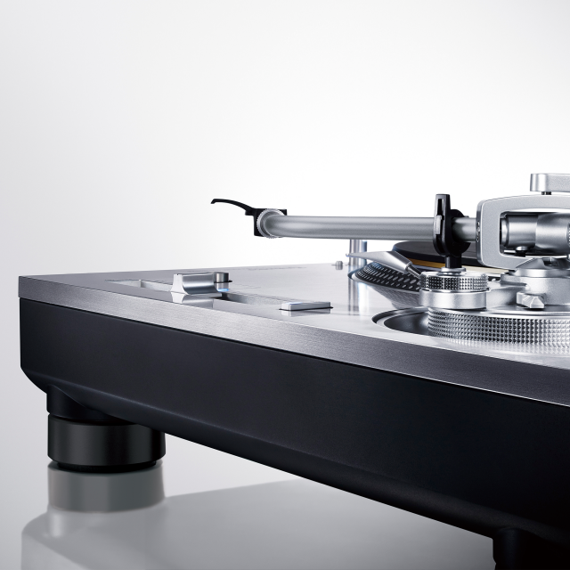 Gros plan sur une platine, mettant en évidence le bras de lecture et une partie du plateau.