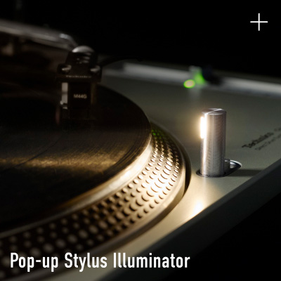 Close-up photograph of the pop-up stylus illuminator on a Technics turntable, glowing against a dark background, with the label "Pop-up Stylus Illuminator" in white text at the bottom left.