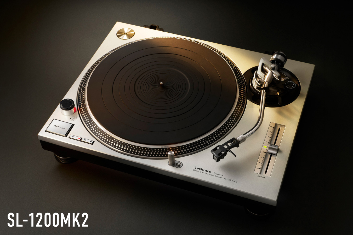 Photograph of the Technics SL-1200MK2 turntable in silver finish, shot from above against a dark background, with the model name "SL-1200MK2" displayed in the lower left.