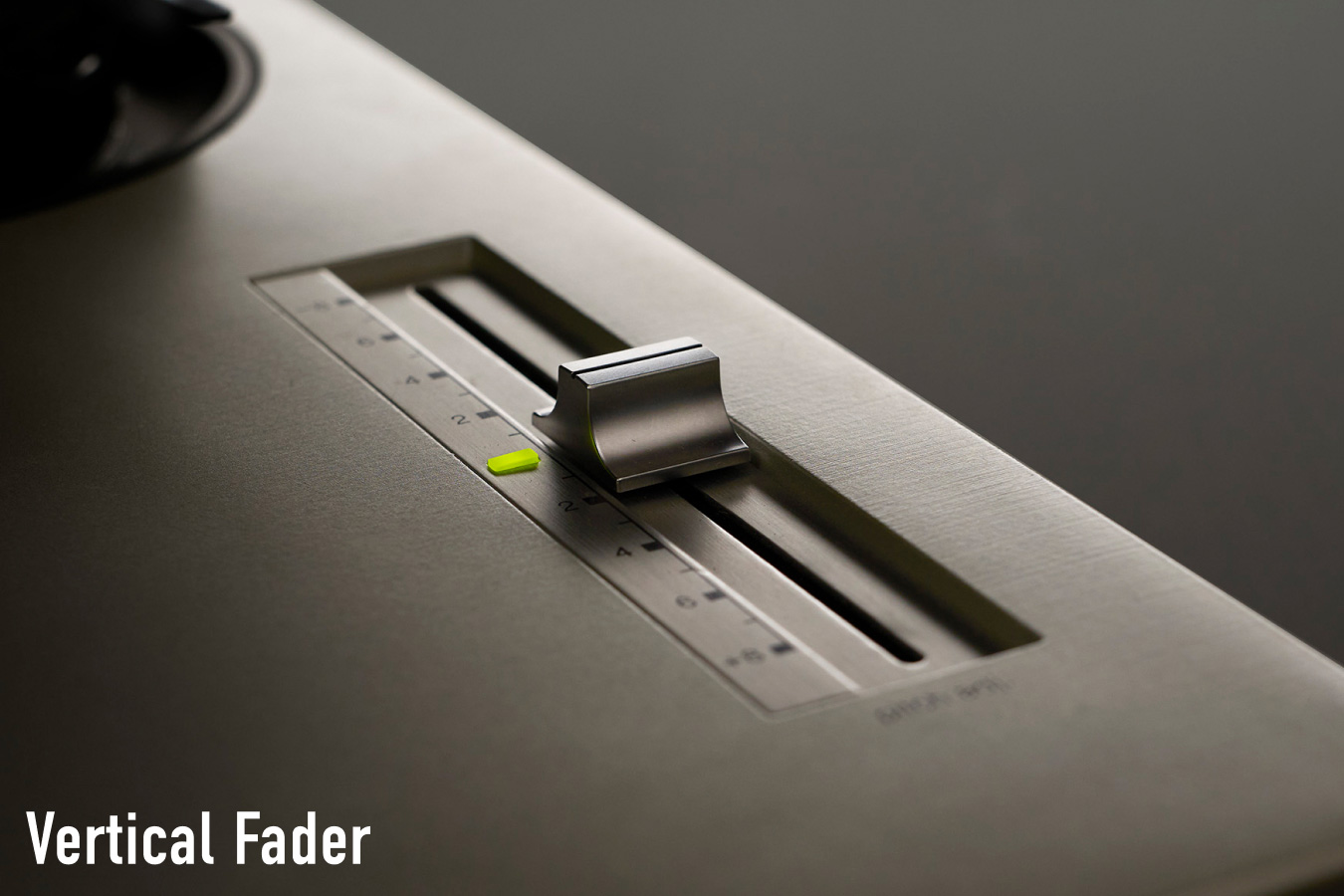 Close-up photograph of the vertical fader on a Technics turntable, with the label "Vertical Fader" in white text at the bottom left.